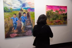 Imagen muestra a una persona de espalda observando las obras del autor